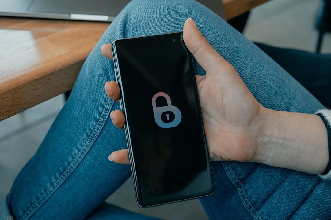 Hand håller en smartphone med en upplåsningssymbol på skärmen
