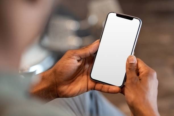 Person håller en smartphone med tom skärm i handen