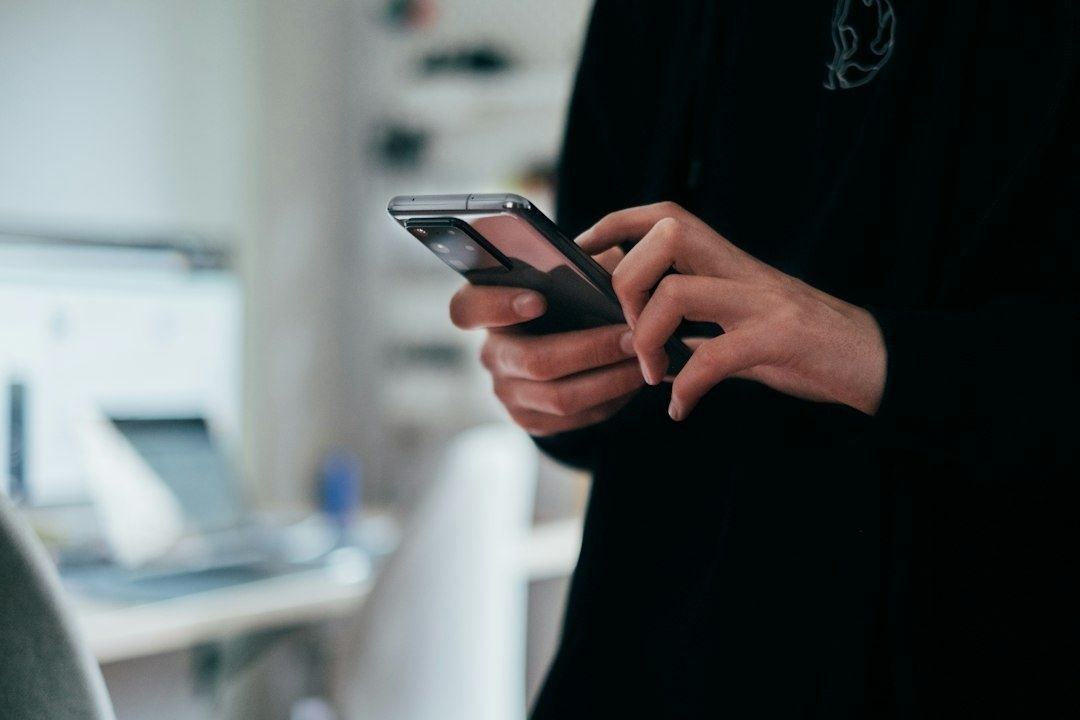 Person håller en modern smartphone med båda händerna